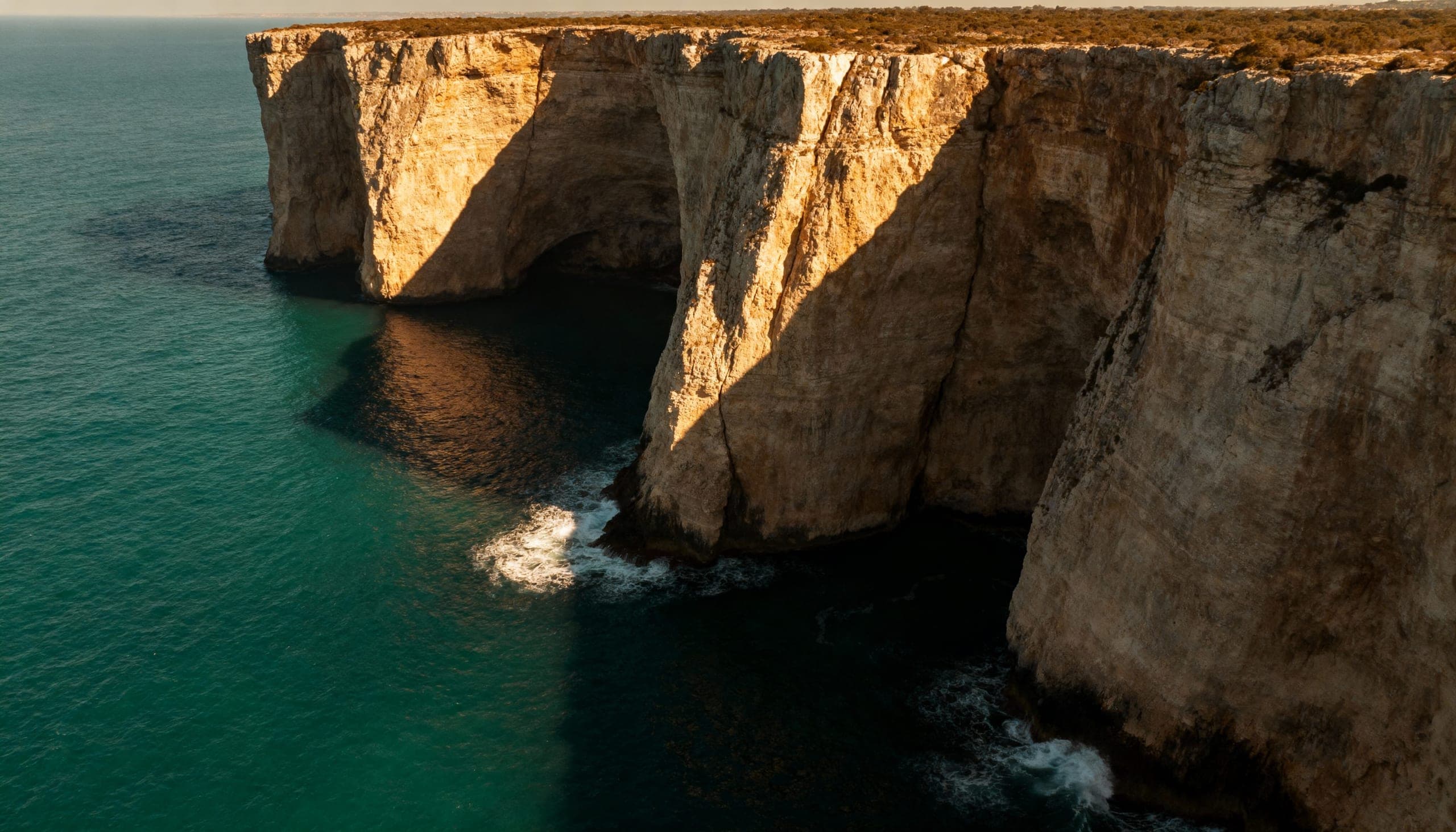 Mediterranean cliffside at golden hour above the sea.